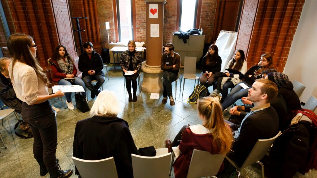 Eine Gruppe sitz im Kreis bei einem Workshop