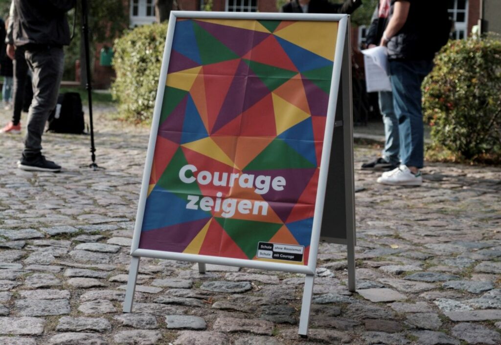 Ein Aufsteller mit einenm Plakat mit der Aufschrift Courage Zeigen